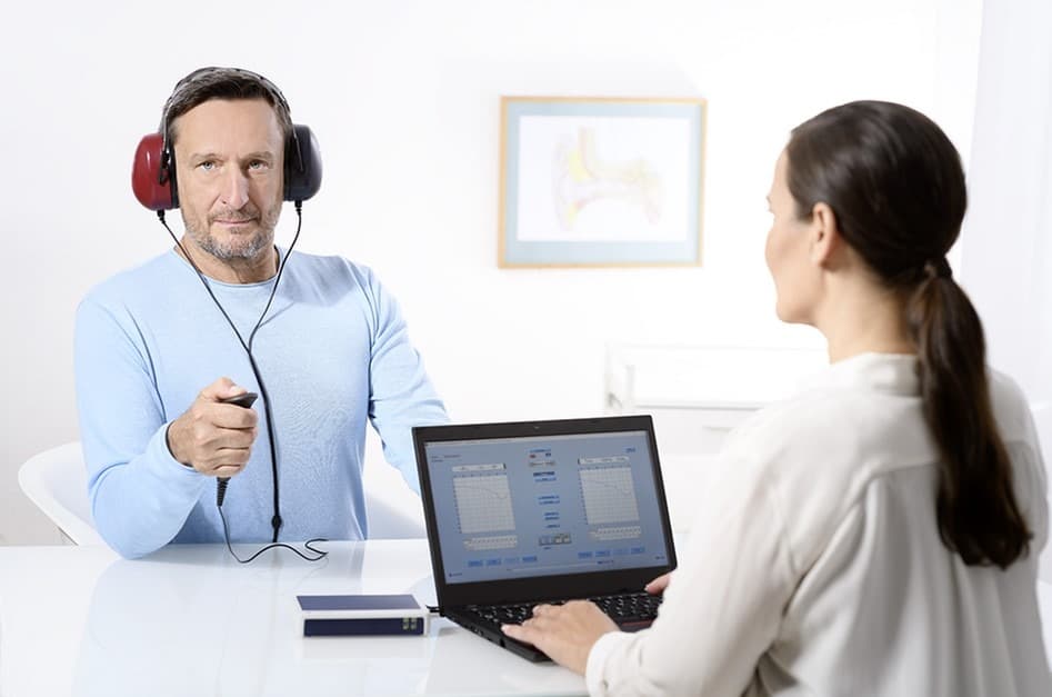 Profesional realizando evaluación auditiva a paciente